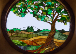 Stained glass showing a madrone tree and Southern Oregon landscape